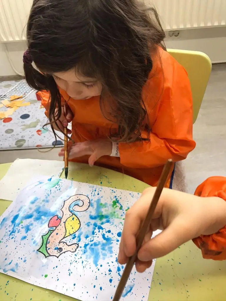 Copil pictând la un atelier creativ